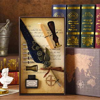 Blue feather quill pen gift set with decorative gear accents and wax sealing accessories beside a map-themed gift box
